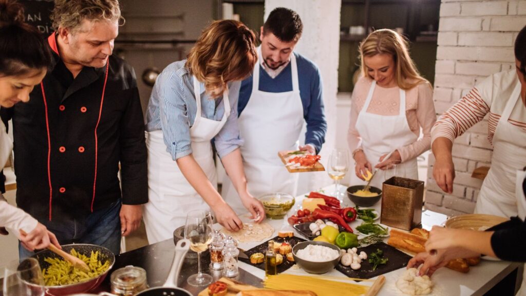 gente cocinando pasta y verduras